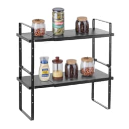 Two black expandable shelves stacked into a 2-tier organizer holding spice and snack jars